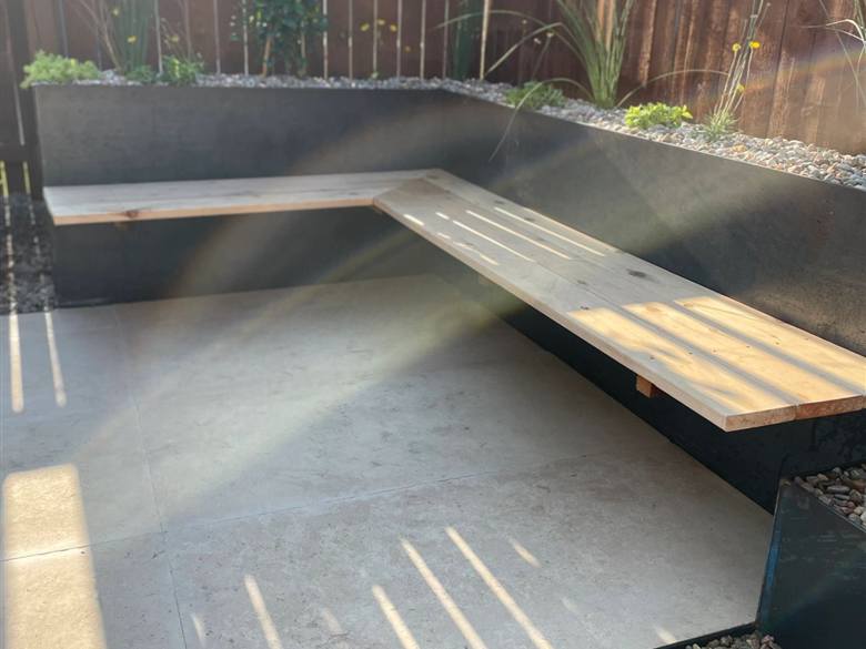 Concrete and steel walkway with river rock hardscaping in Austin